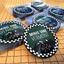 Stacks of custom club badges, all individually wrapped except for the one in front. thumbnail